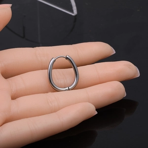 Minimalist Mobius twist geometric stainless steel oval hoop earrings on palm for size