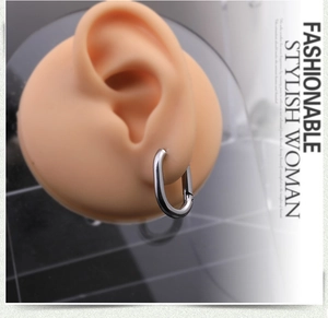 Close-up of a silver Mobius twisted oval earring shown on a silicone ear display model