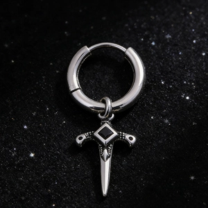 Macro view of silver stainless steel earring featuring a dagger pendant with black gem