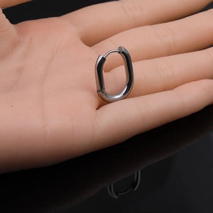 Macro shot of dark grey minimalist stainless steel oval hoop earring with hinged closure