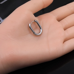 Polished silver U-shaped hoop earring in stainless steel shown on hand for size scaling