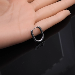Detailed view of gunmetal oval hoop earring on silicone model against black mirror
