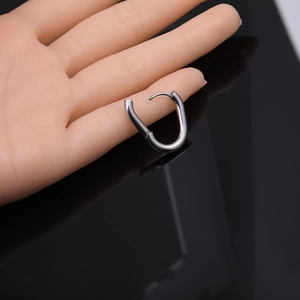Close-up of polished stainless steel Mobius twist earrings on a hand model display