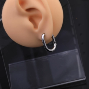 Detailed view of silver Mobius hoop earring on display for minimalist jewelry style