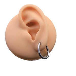 Minimalist Mobius twist hoop earrings in stainless steel on a silicone ear model