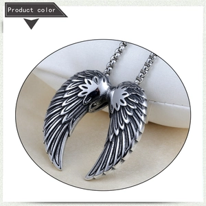 Detailed close-up of retro silver-tone angel wing pendant with intricate feather textures