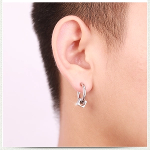 Close-up of hip-hop silver square drop earring worn by a male model for style