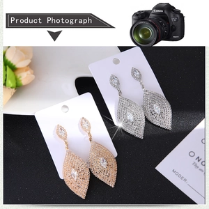 Vue macro de boucles d'oreilles luxueuses en forme de feuille, dorées et argentées avec strass