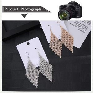 Vue détaillée des boucles d'oreilles losanges en argent et or avec strass brillants