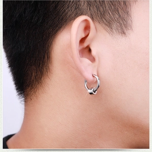 Close-up of minimalist silver hoop earring with cylindrical pendant on male model