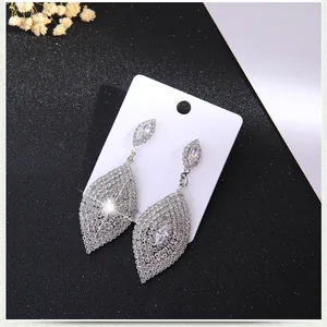 Détail de boucles d'oreilles pendantes en argent avec strass et zircon marquise