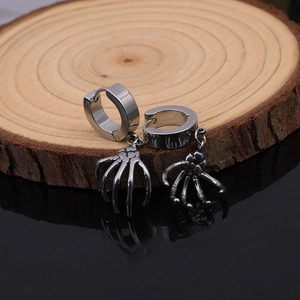 Macro detail of gothic skull hand pendant on a stainless steel hoop earring