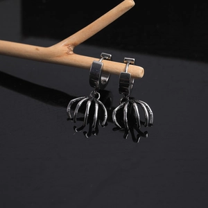 Gothic punk skeleton hand earrings in vintage silver steel displayed on wood branch