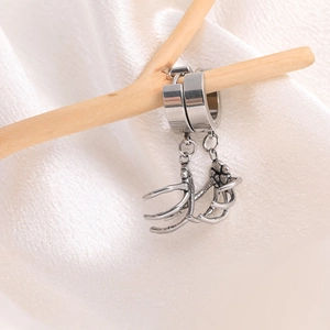 Close-up of gothic stainless steel skeleton hand pendant on silver hoop earrings