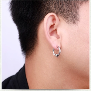 Close-up of minimalist silver hoop earring with movable bead worn by a male model