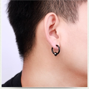 Close-up of matte black hoop earring with cone pendant worn on a male model's ear