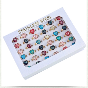 Detailed view of 36 stainless steel heart rings with colorful stones in a white display box