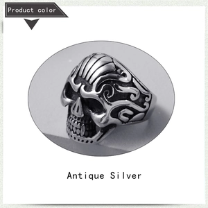 Detailed close-up of antique silver skull ring with ornate floral engravings on the side