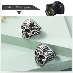 Detail of silver skull rings featuring intricate swirling patterns and gothic punk style