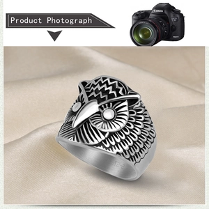 Detailed close-up of retro silver owl ring with intricate feather textures on satin