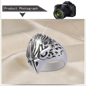 Macro shot of silver punk skull ring on silk fabric with detailed bird wing textures
