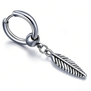 Gros plan sur une boucle d'oreille punk en acier inoxydable avec un pendentif plume