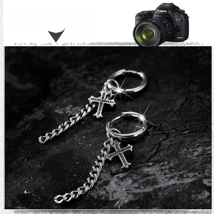 Détail de boucles d'oreilles créoles en acier inoxydable avec pendentif croix sur pierre