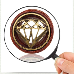 Dettaglio macro di dilatatore retrò con anello in legno e motivo a diamante in metallo