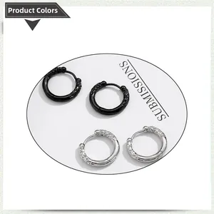 Detail of vintage engraved stainless steel hoop earrings in black and silver finishes