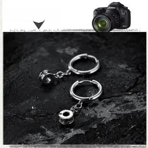 Detailed macro shot of polished stainless steel hoop earring with engraved wheel pendant