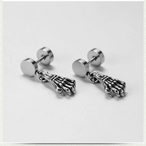Close-up of stainless steel gothic skull hand earrings with vintage black oxidation