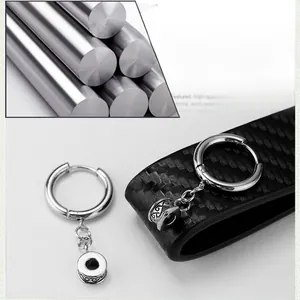 Detail of titanium steel hoop earrings with industrial vintage cylinder charms