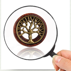 Detailed close-up of retro wooden ear gauge plug with metallic tree of life design