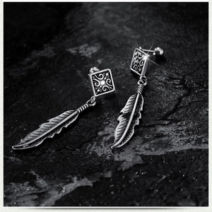 Vintage stainless steel cross feather drop earrings with antique silver finish on dark stone