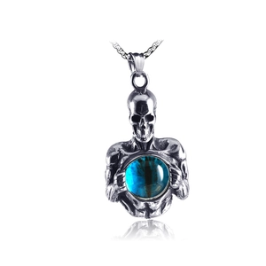 Close-up of gothic stainless steel skull pendant holding a blue nebula crystal sphere