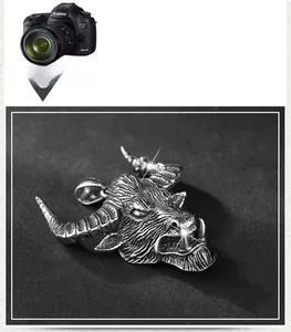 Detailed close-up of retro silver stainless steel bull head pendant with punk engraving