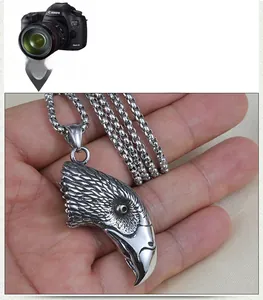 Macro detail of vintage silver eagle head pendant with intricate feather texture on chain