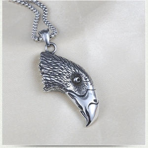 Macro detail of vintage stainless steel eagle head pendant with intricate feather texture