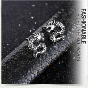 Detailed close-up of dragon stud earrings in antique silver finish with scaled textures