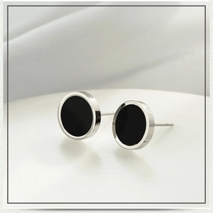 Vue latérale de boucles d'oreilles barbell en acier avec opale noire sur support blanc