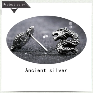Macro shot of ancient silver dragon stud earrings with detailed scales and texture