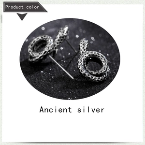 Macro shot of ancient silver snake earrings with textured scales and vintage finish