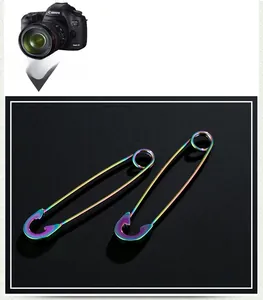 Detail shot of two iridescent rainbow finish safety pin earrings in punk style metal