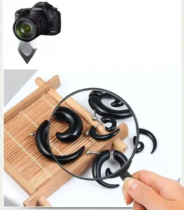 Detailed view of black acrylic spiral ear tapers with smooth polished finish