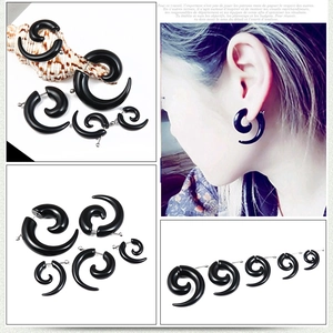 Detail of black acrylic spiral ear tapers showing multiple gauges for ear piercing