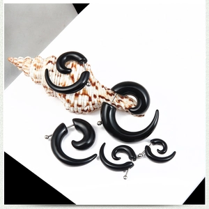 Macro detail of black spiral acrylic ear gauges in various sizes with silver studs