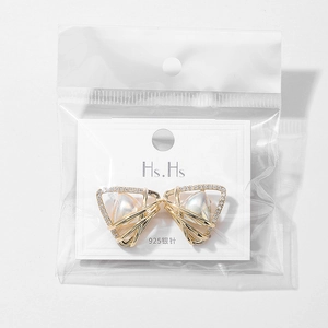 Detail of gold triangle earrings with central pearl and stones on 925 silver needle