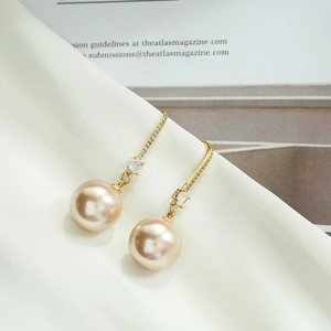 Gros plan sur les boucles d'oreilles perles champagne avec cristaux scintillants