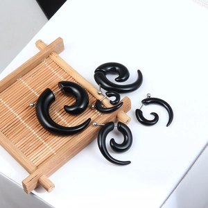 Five-piece set of black spiral ear tapers with polished finish on a wooden tray