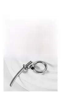Close-up of hip hop style silver earring featuring a detailed samurai sword pendant